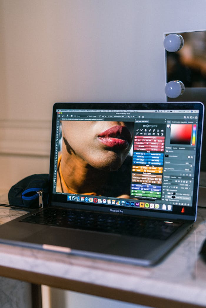 why-choose-us A laptop displaying a graphic design software interface in a creative workspace.